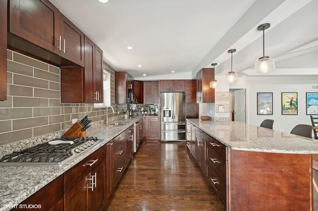 kitchen featuring backsplash, a sink, a peninsula, stainless steel appliances, and dark wood-type flooring