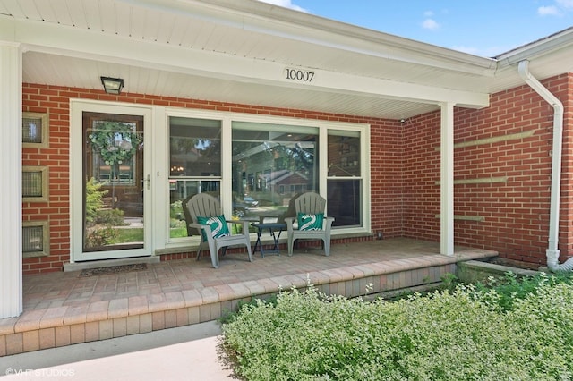 view of exterior entry featuring brick siding