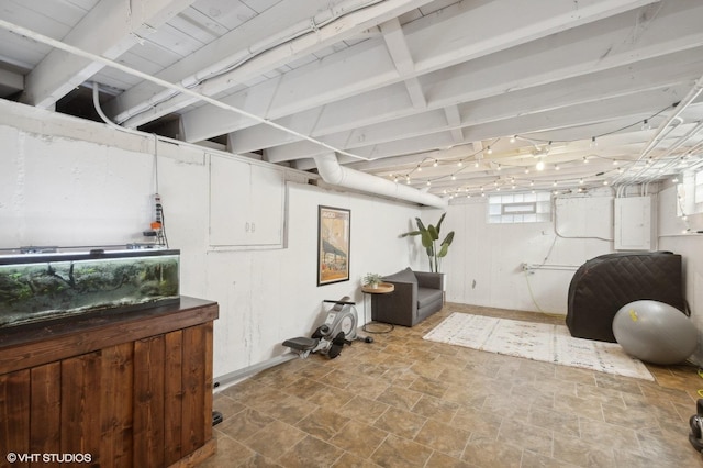 below grade area with baseboards and stone finish flooring
