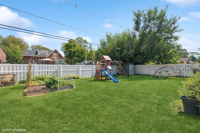 view of yard with a fenced backyard, a playground, and a vegetable garden