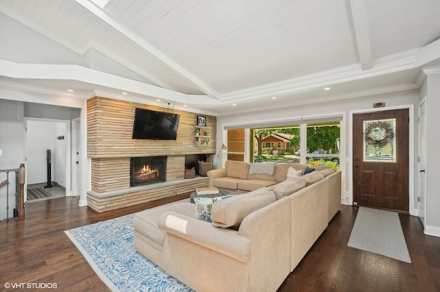 living area featuring vaulted ceiling with beams, dark wood-style flooring, a lit fireplace, and wooden ceiling