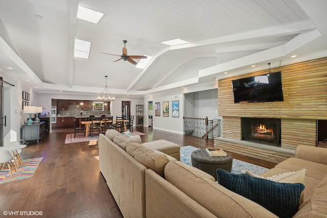 living area featuring dark wood-style flooring, a brick fireplace, ceiling fan with notable chandelier, recessed lighting, and lofted ceiling with skylight
