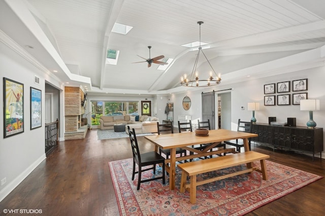 dining space with a ceiling fan, a barn door, wood finished floors, baseboards, and lofted ceiling with skylight