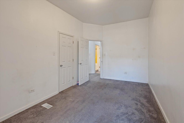 carpeted empty room featuring visible vents and baseboards