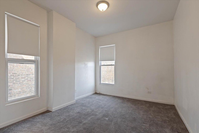 carpeted empty room featuring baseboards