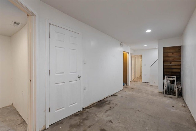 corridor featuring concrete flooring and visible vents