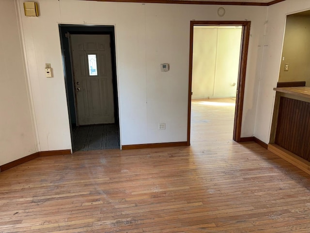 spare room with baseboards and hardwood / wood-style flooring