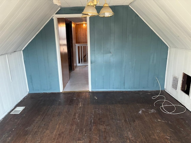 bonus room featuring wood-type flooring, visible vents, and vaulted ceiling