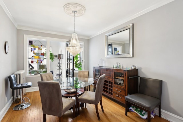 1606 W Winona St Unit 3, Chicago, IL 60640 - dining area with baseboards, an inviting chandelier, crown molding, radiator, and light wood-style flooring