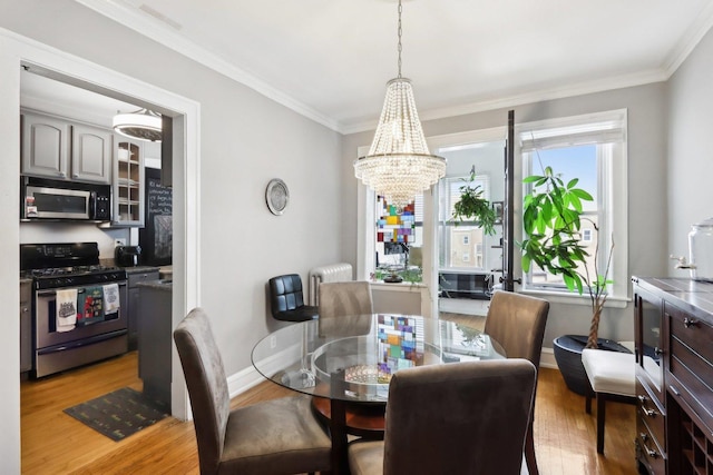 1606 W Winona St Unit 3, Chicago, IL 60640 - dining space featuring ornamental molding, baseboards, light wood-type flooring, and an inviting chandelier