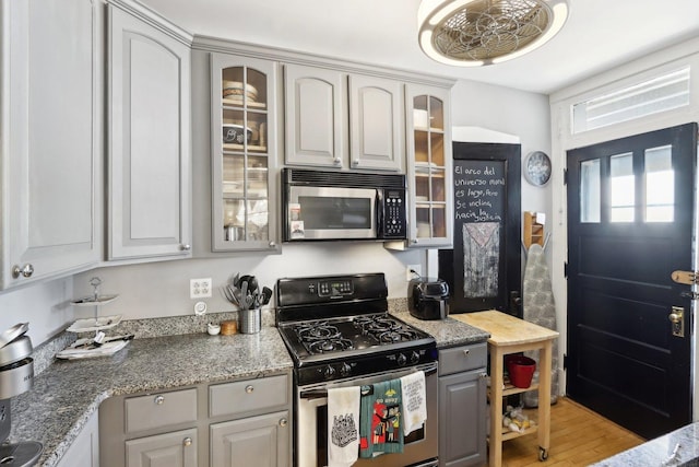 1606 W Winona St Unit 3, Chicago, IL 60640 - kitchen featuring light wood-style floors, gray cabinetry, glass insert cabinets, and stainless steel appliances