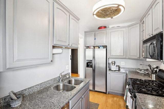 1606 W Winona St Unit 3, Chicago, IL 60640 - kitchen with dark stone countertops, a sink, appliances with stainless steel finishes, light wood finished floors, and gray cabinets