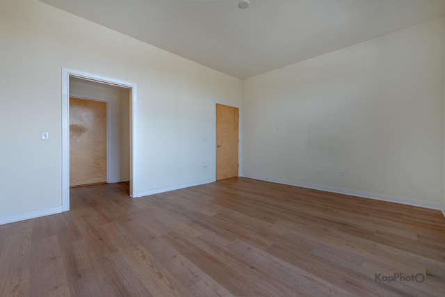 empty room featuring baseboards and wood finished floors