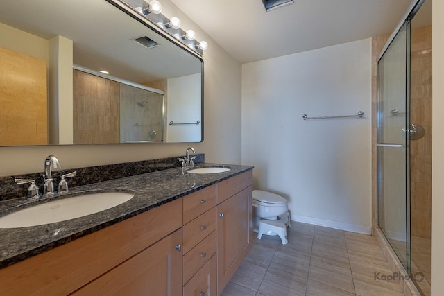 bathroom featuring toilet, visible vents, a sink, and a stall shower