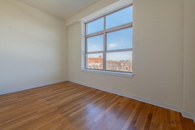 unfurnished room featuring light wood-style floors and baseboards