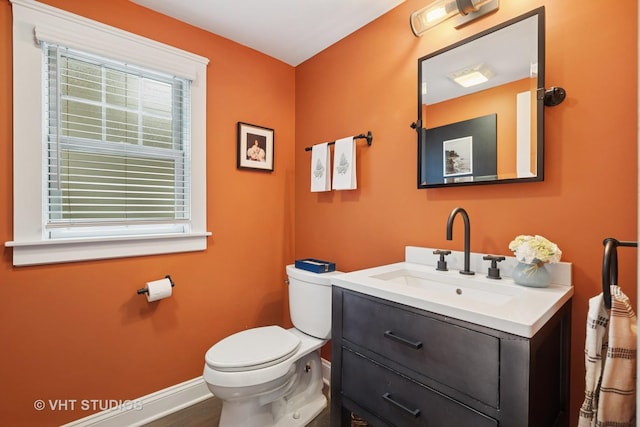 bathroom with vanity, baseboards, and toilet
