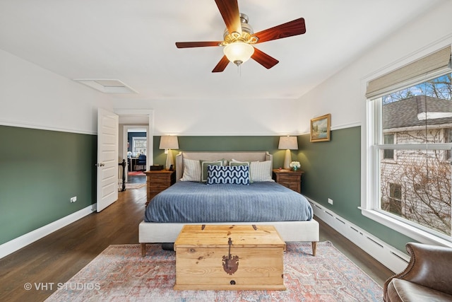 bedroom with baseboard heating, wood finished floors, attic access, and baseboards