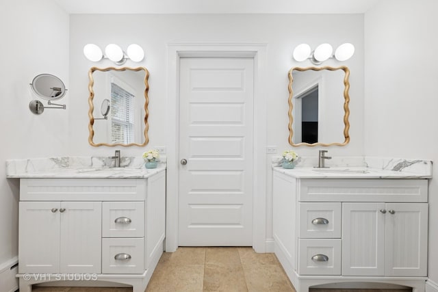 bathroom featuring a sink, two vanities, and a baseboard radiator