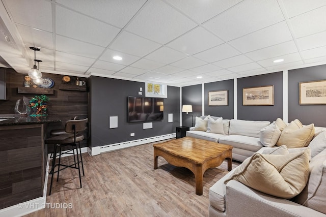 living room with light wood-type flooring, a paneled ceiling, recessed lighting, and baseboard heating