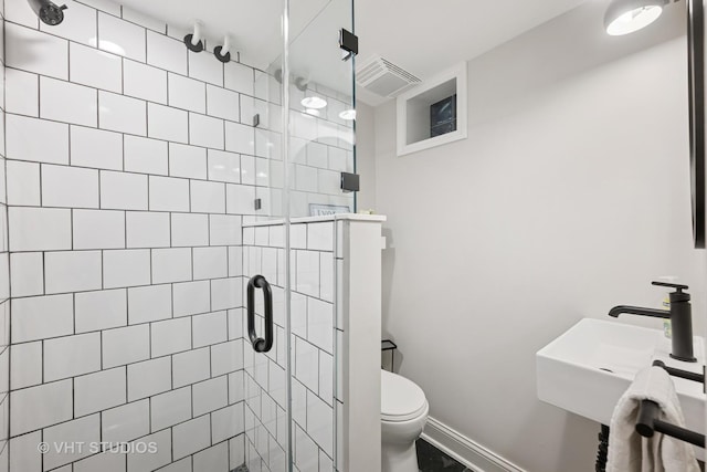 bathroom featuring a shower stall, visible vents, a sink, and toilet