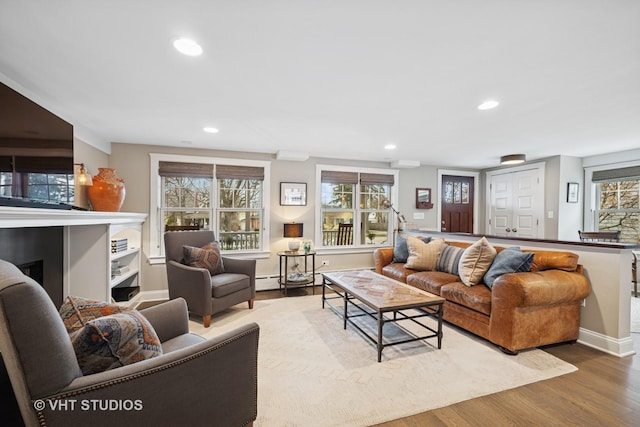 living area featuring recessed lighting, baseboards, and wood finished floors
