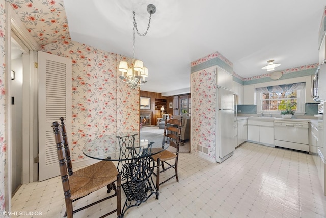 3916 Franklin Ave, Western Springs, IL 60558 - dining room featuring a wealth of natural light, an inviting chandelier, light floors, and wallpapered walls