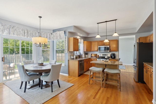 18485 W Springwood Dr, Grayslake, IL 60030 - kitchen featuring appliances with stainless steel finishes, a center island, light wood finished floors, and healthy amount of natural light
