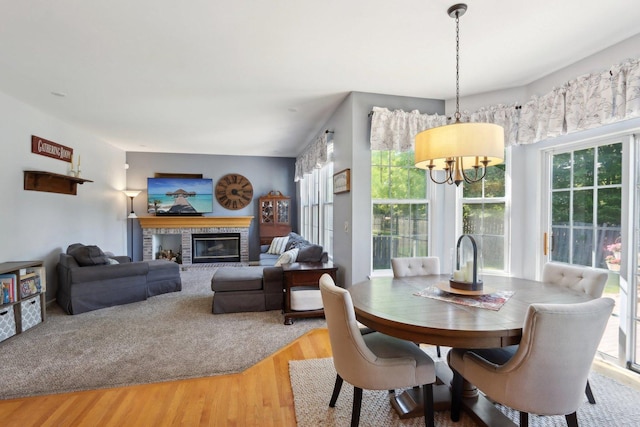 18485 W Springwood Dr, Grayslake, IL 60030 - dining space with a chandelier, light wood-style flooring, and a brick fireplace