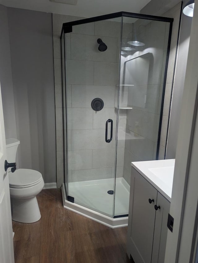 18485 W Springwood Dr, Grayslake, IL 60030 - bathroom featuring wood finished floors, vanity, toilet, a stall shower, and baseboards