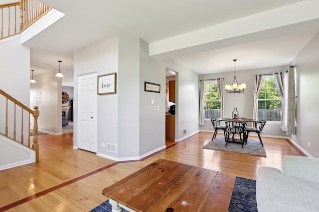 18485 W Springwood Dr, Grayslake, IL 60030 - living room featuring light wood-style flooring, stairway, a chandelier, and baseboards