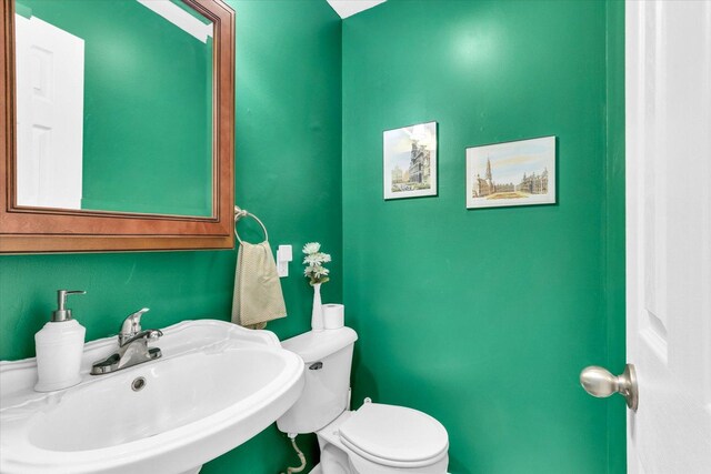 half bath featuring a sink and toilet