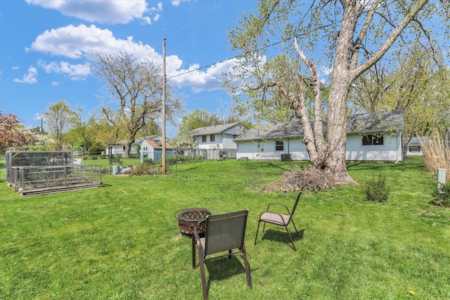 view of yard featuring an outdoor fire pit and fence