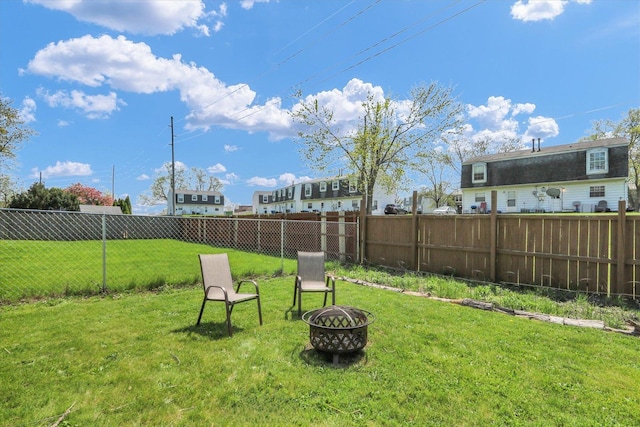 view of yard with fence and a fire pit