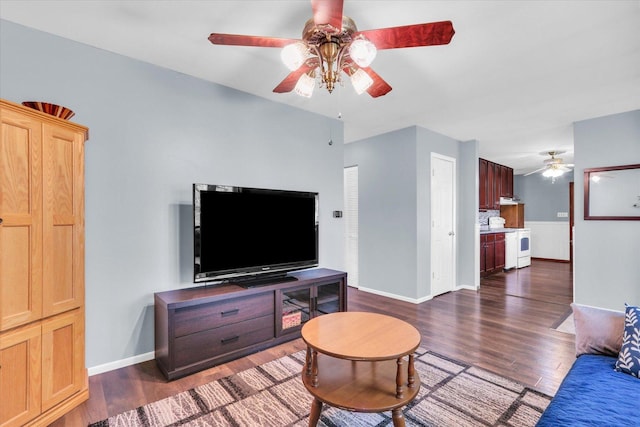 living room with a ceiling fan, baseboards, and dark wood-type flooring