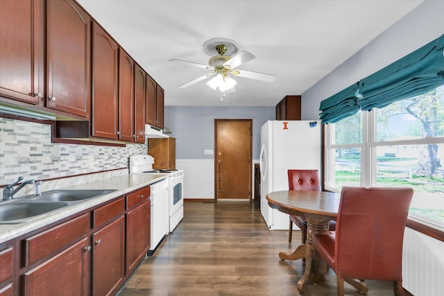 kitchen with dark wood-style flooring, a sink, light countertops, under cabinet range hood, and white appliances