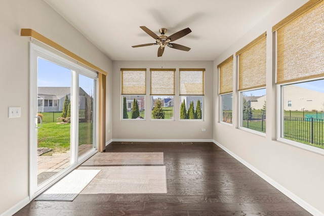 unfurnished sunroom featuring wood finished floors and baseboards