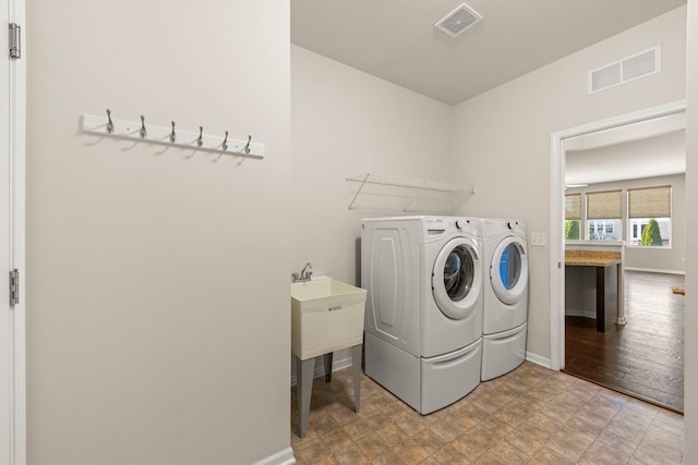 washroom with washer and dryer, visible vents, laundry area, and baseboards