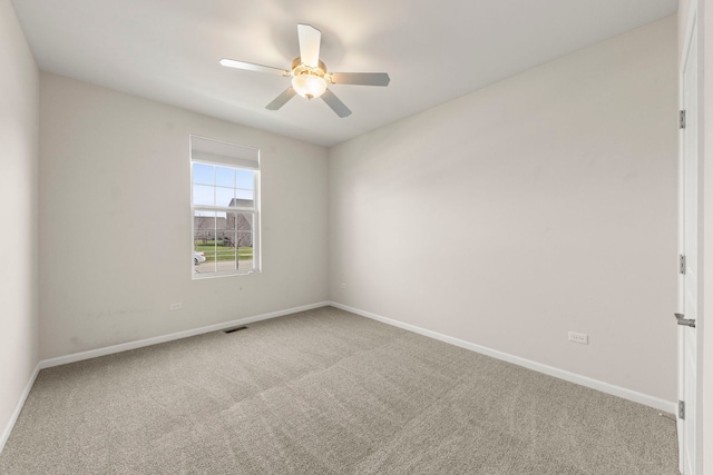 carpeted empty room featuring visible vents, baseboards, and a ceiling fan