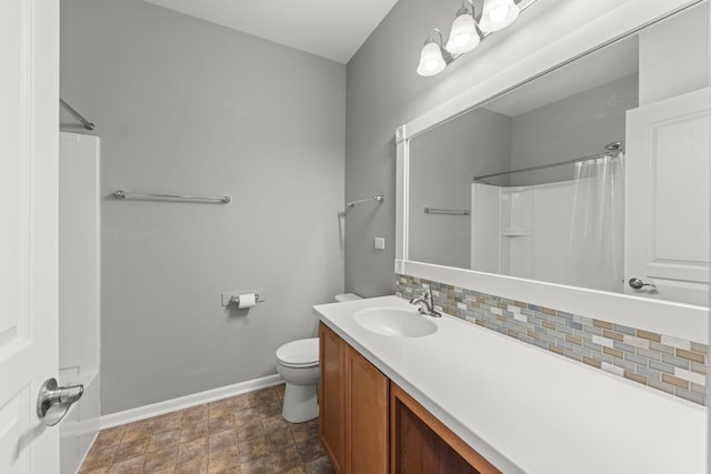 full bathroom featuring tasteful backsplash, stone finish floor, vanity, toilet, and baseboards
