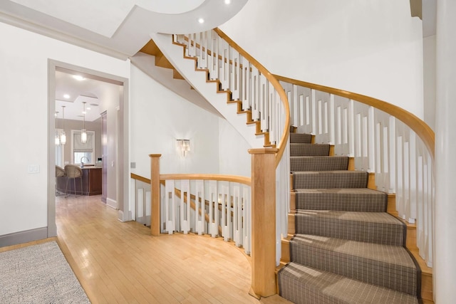 staircase with wood-type flooring and baseboards
