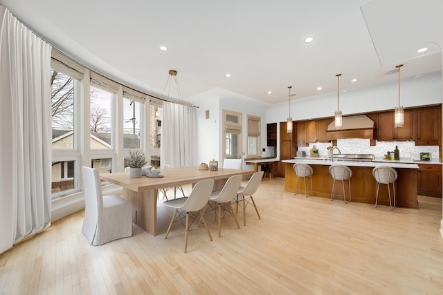 dining space with light wood finished floors and recessed lighting