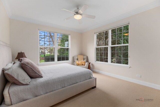 carpeted bedroom with baseboards, ornamental molding, and ceiling fan