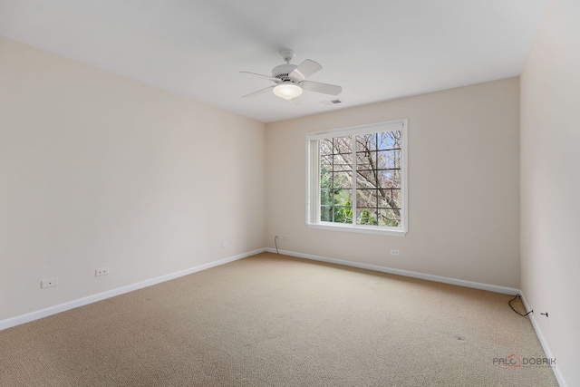 carpeted empty room with baseboards, visible vents, and a ceiling fan