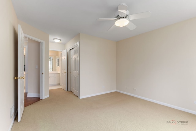 unfurnished bedroom with baseboards, visible vents, a closet, and light colored carpet