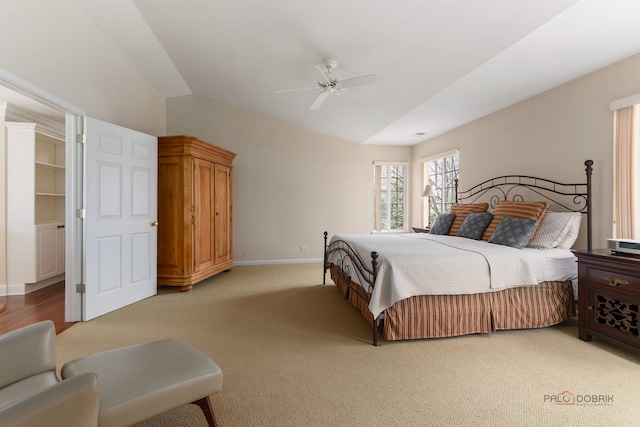 bedroom with a ceiling fan, light carpet, lofted ceiling, and baseboards