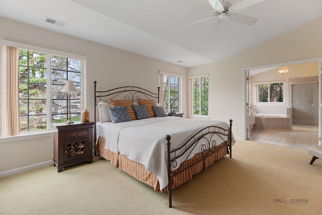 bedroom featuring light carpet, ensuite bathroom, baseboards, visible vents, and lofted ceiling