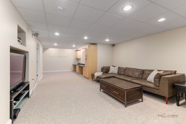 living room with baseboards, recessed lighting, light carpet, and a drop ceiling