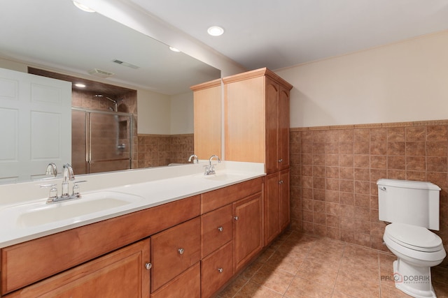 full bath with tile patterned flooring, tile walls, a sink, and a shower stall