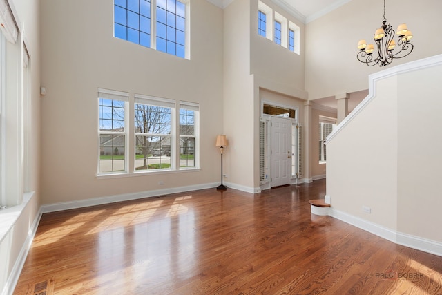 foyer featuring a towering ceiling, a healthy amount of sunlight, visible vents, and a notable chandelier