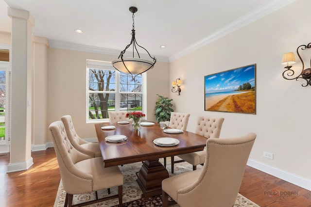 dining room with ornamental molding, decorative columns, wood finished floors, and baseboards